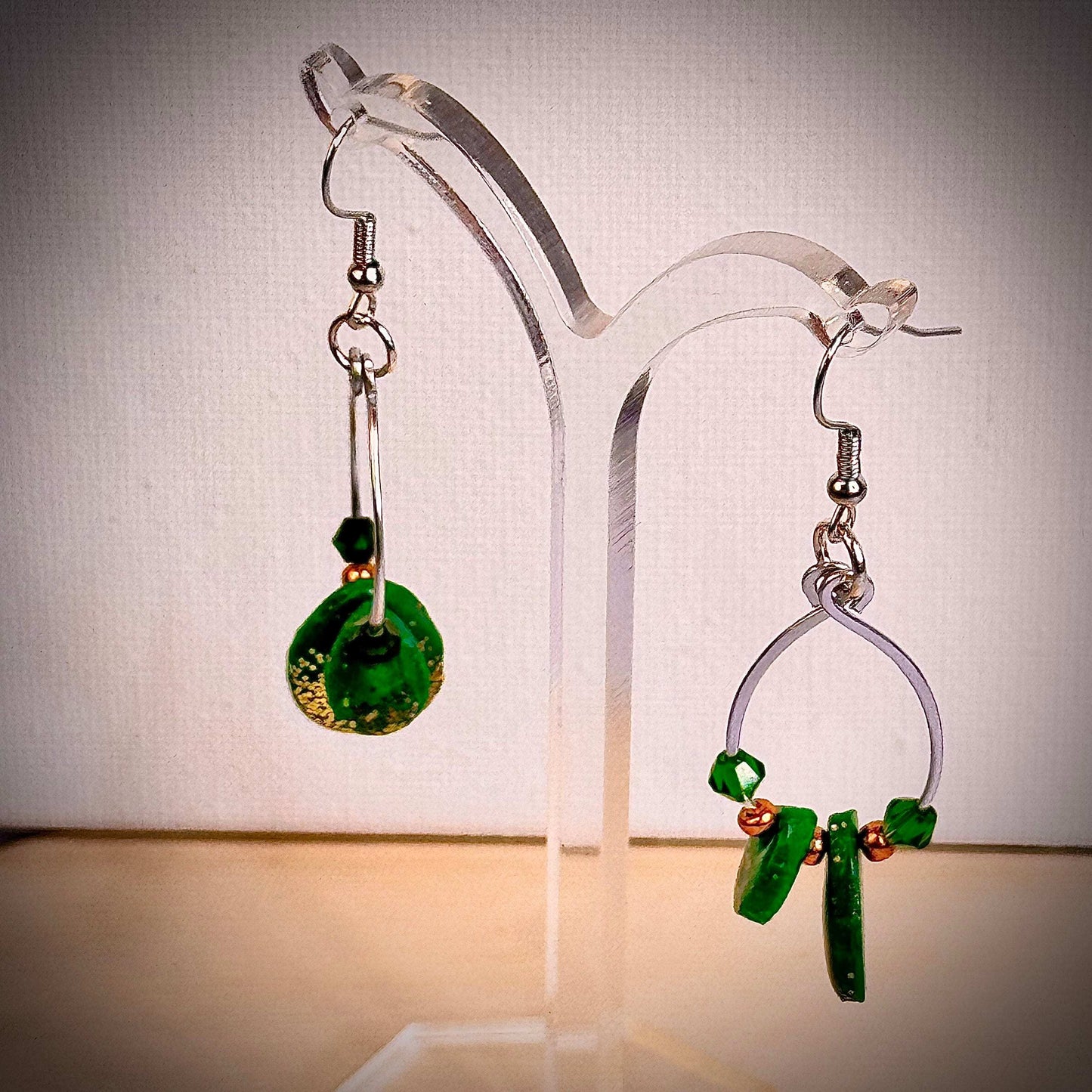 Emerald Essence dangle earrings with hammered wire loops, vibrant green polymer clay, and sparkling glass beads. Handmade statement earrings perfect for adding a touch of elegance and style.