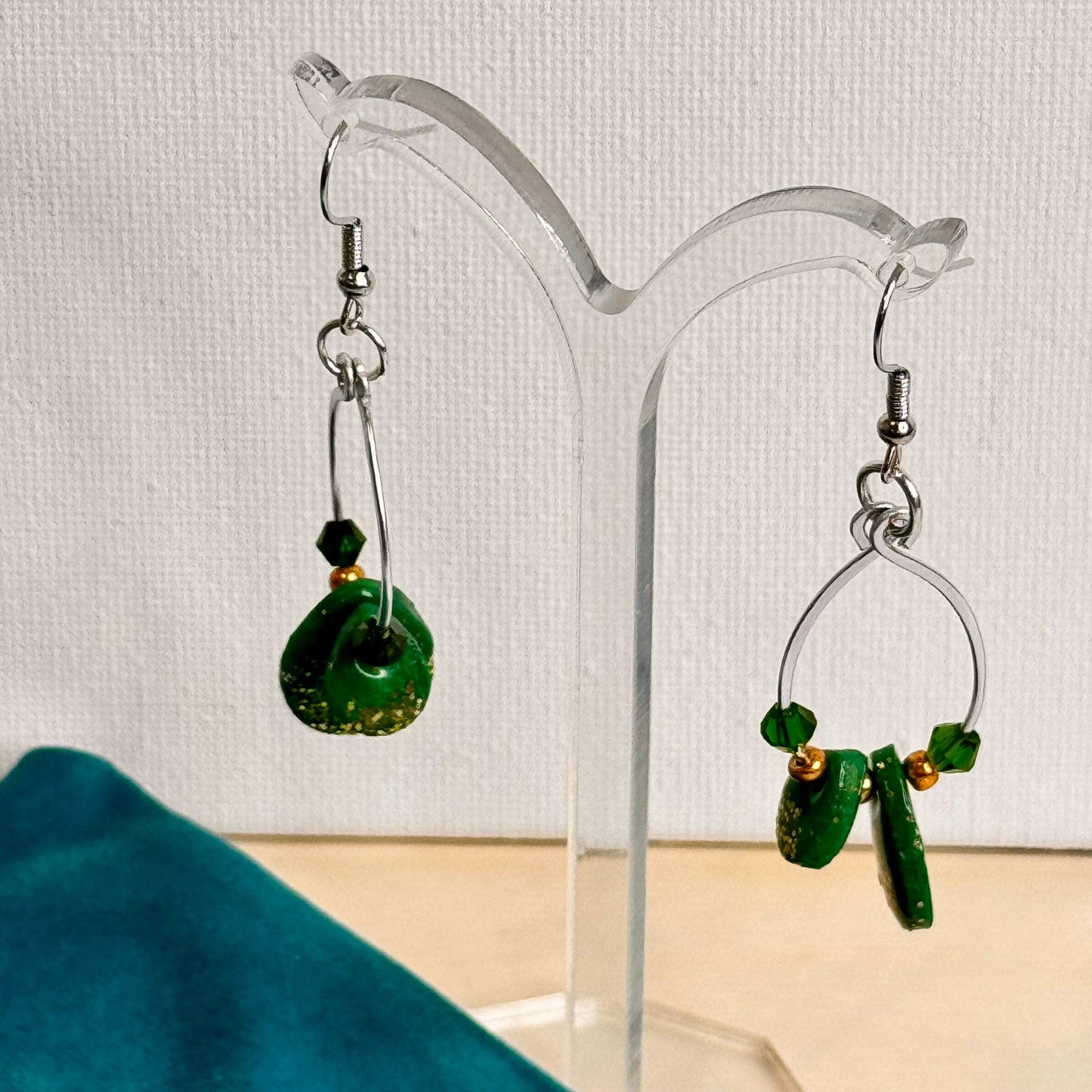 Emerald Essence dangle earrings with hammered wire loops, vibrant green polymer clay, and sparkling glass beads. Handmade statement earrings perfect for adding a touch of elegance and style.