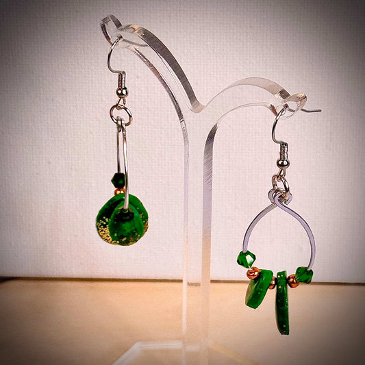 Emerald Essence dangle earrings with hammered wire loops, vibrant green polymer clay, and sparkling glass beads. Handmade statement earrings perfect for adding a touch of elegance and style.