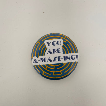 Round button saying amazing sits in the center of the button. A yellow maze on a blue background sit behind the wording.