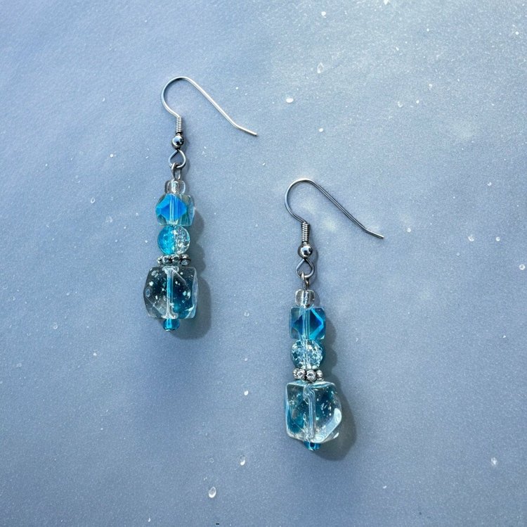 Light blue cubed beads stacked on top of each other to form dangle earrings.