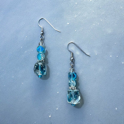 Light blue cubed beads stacked on top of each other to form dangle earrings.