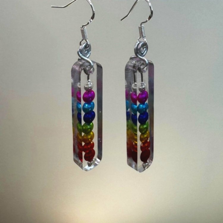 Rainbow colored shiny beads encased in resin making a rectangular dangle earring.
