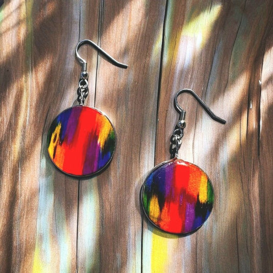 Rainbow design where each color bleeds into the other on a wooden circle.